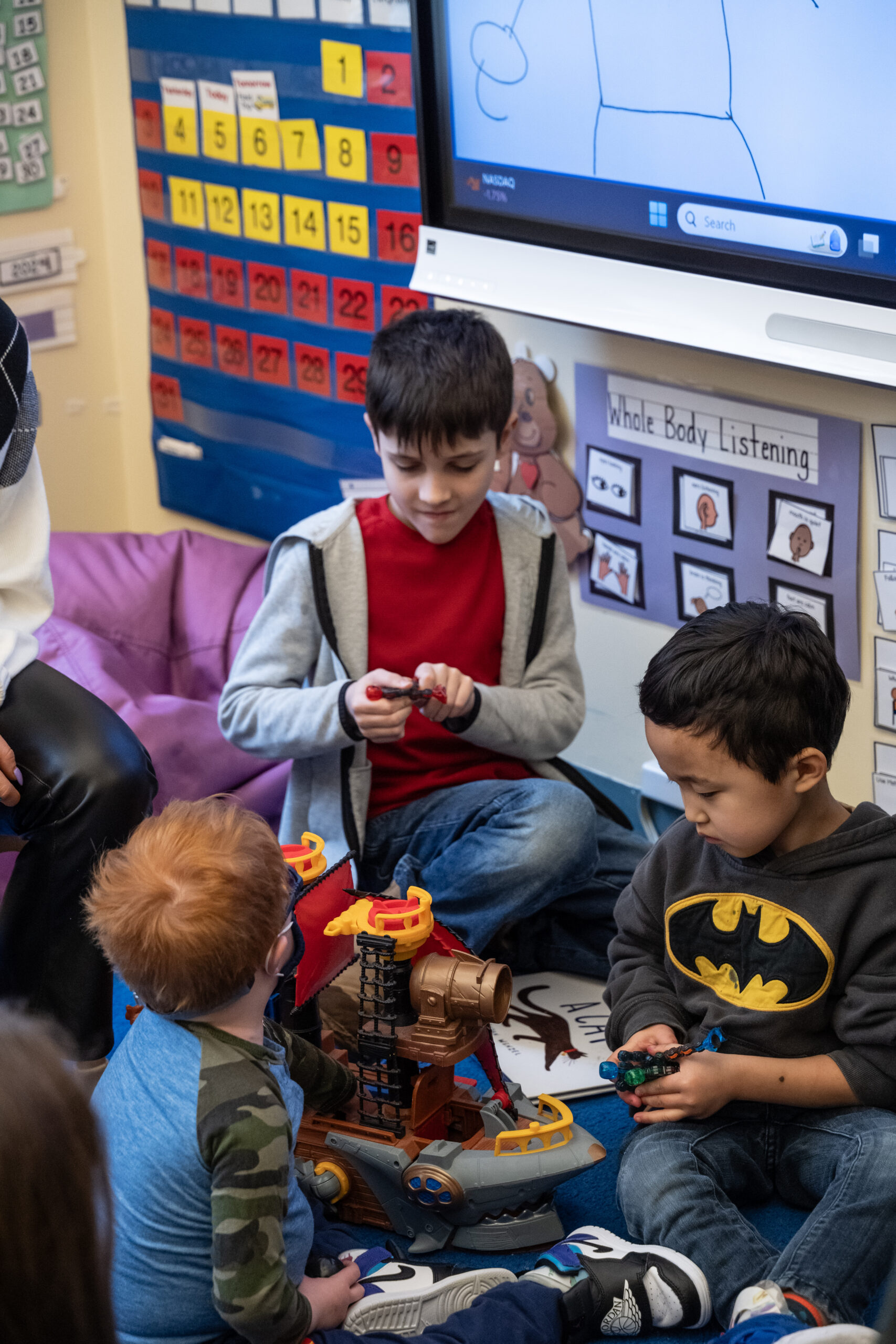 child students in a group playing trains